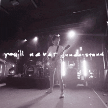 a black and white photo of a man playing a guitar with the words you 'll never understand above him