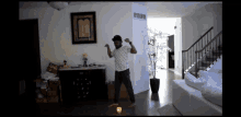 a man is dancing in a living room in front of a picture of the bible