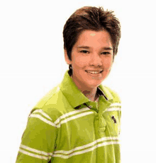 a young boy wearing a green striped polo shirt is smiling .