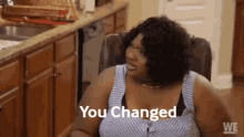 a woman is sitting in a chair in front of a kitchen counter with the words " you changed " above her