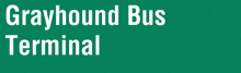 a green sign says grayhound bus terminal in white letters