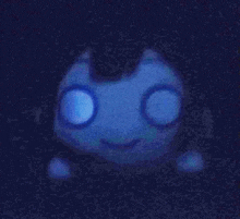 a glow in the dark stuffed animal with glowing eyes is sitting on a table .