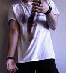 a man wearing a white t-shirt with blood on it .