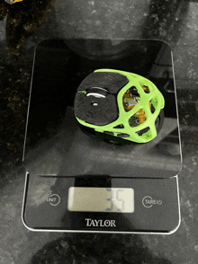 a black taylor scale with a green object on it