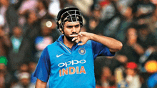 a man wearing a helmet and a blue shirt that says oppo india