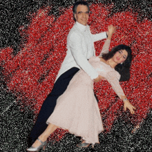 a man and woman are dancing in front of a red background