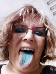 a woman wearing glasses is sticking her tongue out