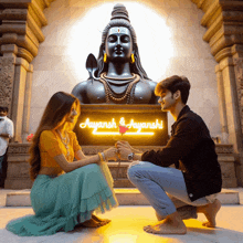 a couple kneeling in front of a sign that says aayansh and ayanshi