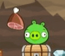 a green pig is sitting on top of a barrel in a video game .