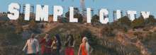 a group of people are walking in front of a sign that says simplicity