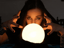 a woman is looking through a crystal ball with her eyes closed