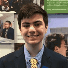 a young man is wearing a suit and tie and smiling .