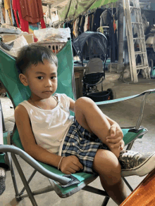 a young boy is sitting in a green chair