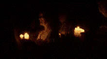 a blurry picture of a woman holding candles in the dark