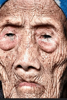 a close up of an older woman 's face with a blue hat on