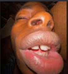 a close up of a person 's face with their tongue out .