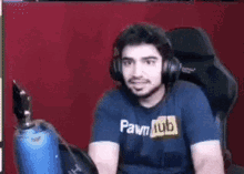 a man wearing headphones and a blue shirt that says pawn hub