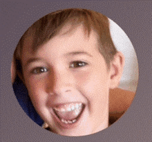 a close up of a child 's face in a circle with his tongue out