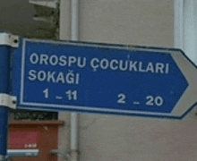 a blue street sign points towards orospul cocuklari sokagi