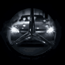 a close up of a mercedes logo with the headlights on