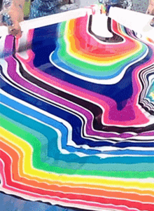 a painting of a rainbow colored swirl on a table