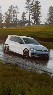 a white volkswagen golf is driving down a muddy road