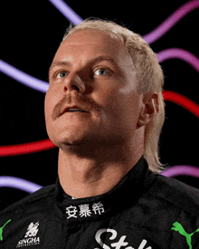 a man with blonde hair and a mustache is wearing a black shirt with singha written on it