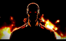 a man with red eyes is standing in front of a fire in the dark .