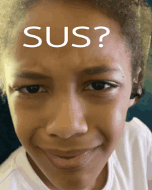 a close up of a child 's face with the word sus written on her forehead