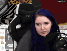 a woman with blue hair is sitting in a swiftmo gaming chair