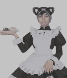 a person in a maid costume holds a plate of food