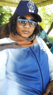 a woman wearing sunglasses and a hat that says paris saint-germain