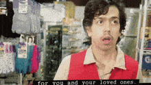 a man in a red vest stands in front of a sign that says for you and your loved ones