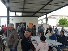 a group of people sitting at tables under a canopy with a sign that says ' a ' on it in orange