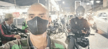 a man wearing a face mask is taking a selfie with an oppo reno4 f camera