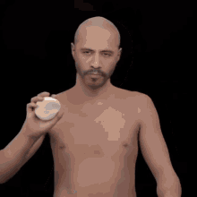 a bald man with a beard is being painted