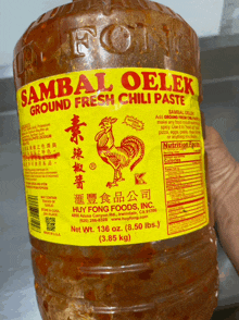 a bottle of sambal oelek ground fresh chili paste is being held in someone 's hand