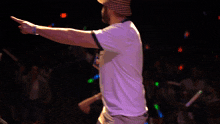 a man wearing a plaid hat and a white shirt is pointing