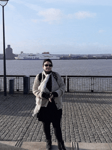 a woman stands in front of a stena line ship in the background