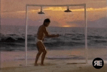 a man is dancing on a beach under a shower