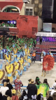 a group of people are watching a carnival parade with a red banner that says ' rio ' on it