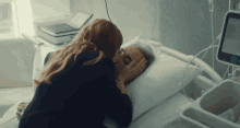 a woman kissing a man in a hospital bed