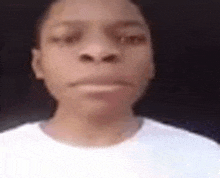 a close up of a young man 's face wearing a white shirt .