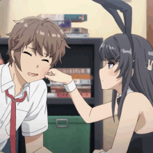 a girl with bunny ears is petting a boy 's cheek