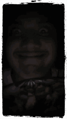 a man 's face is shown in the dark with a white frame around it