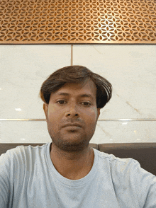 a man taking a selfie in front of a wall with a geometric pattern