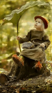 a little girl is sitting on a tree stump holding a leaf and a hedgehog .