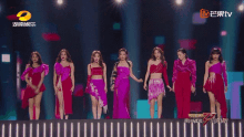 a group of women are standing on a stage with a chinese tv logo in the background