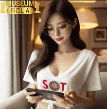 a woman wearing glasses and a white shirt that says sot is looking at her phone