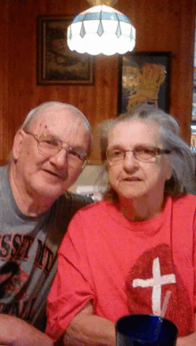 an elderly couple posing for a picture with the man wearing a t-shirt that says ' sd ' on it